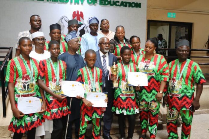 Nigerian Debate Champions1 The Honourable Minister of State for Education, Hon. Dr. Yusuf Tanko Sununu (C), Hon. Usman Muhammad Chairman National Advisory Board (in white Native) and Team Benue Champions during the presentation of awards at FME headquarters Abuja.