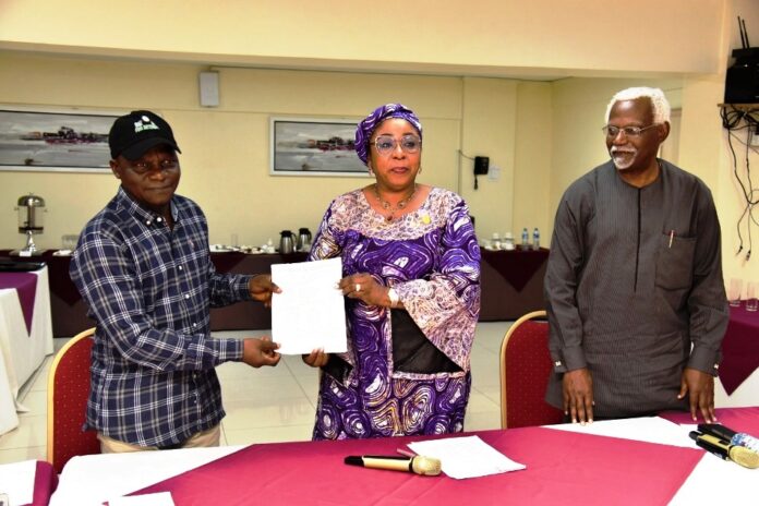 Consequential Salaries Adjustments Committee Head of the Civil Service of the Federation, Mrs Didi Esther Walson-Jack, OON,mni( middle), presenting a copy of the signed Memoranda of Understanding(MOU) on Consequential Adjustments in Salaries to the National Chairman,JNPSNC Comrade Benjamin Anthony(L), while the Chairman, National Salaries, Incomes and Wages Commission, Mr Ekpo Nta(R), looks on.