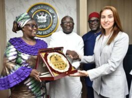 The representative of the Permanent Secretary MPR, Engr. Kamoru Busari FNSE (centre) being assisted by the Director, Gas Department, Mrs. Oluremi Komolafe (left) while presenting a souvenir to the Head of Sustainability Investments, Dr. Miray Zaki during the meeting.