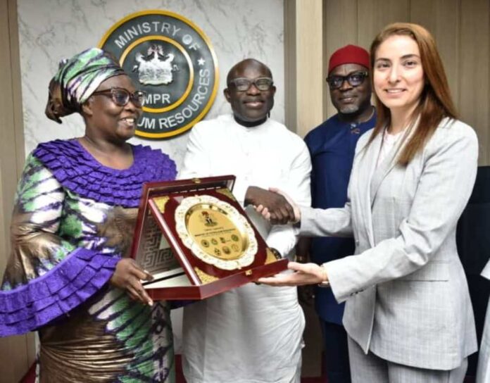 FG Partners With FOSSREA The representative of the Permanent Secretary MPR, Engr. Kamoru Busari FNSE (centre) being assisted by the Director, Gas Department, Mrs. Oluremi Komolafe (left) while presenting a souvenir to the Head of Sustainability Investments, Dr. Miray Zaki during the meeting.