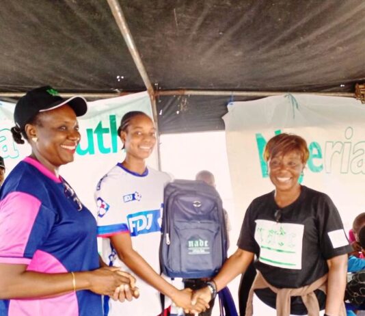 R- L: The Project Manager, Anti-Doping for the National Youth Games and the Chief Executive Officer NADC, Ms. Fadeke Fadeyibi, in a handshake with the Pricer Winner,; Jenifer Ehioziobue of Delta State and NADC Official