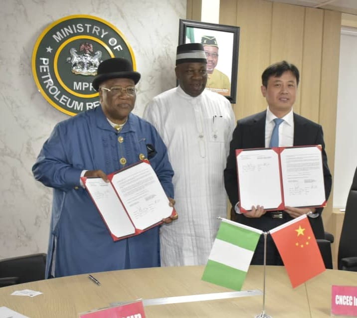 The Representative of the Honourable Minister and Permanent Secretary, MPR. Amb. Nicholas Agbo Ella (center) in a photograph with the Chairman of BFI Group, Dr. Reuben Jaja (left) and the Chairman of China National Chemical Engineering Corporation (CNCEC) as they displayed the signed Agreement Documents.