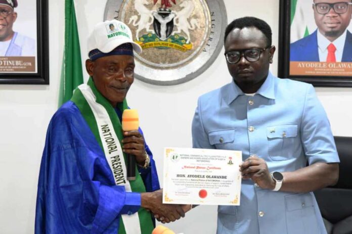NATOMORAS 1 The Honourable Minister, Federal Ministry of Youth Development, Comrade Ayodele Olawande receiving certificate of membership from the National President, NATOMORAS, Ahj. Usman Buba Gwoza, at Abuja.
