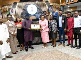 Head of the Civil Service of the Federation, Mrs. Didi Esther Walson-Jack, OON, mni, pose with the symbolic certificate of the Online Compendium of Circulars with members of the technical team.