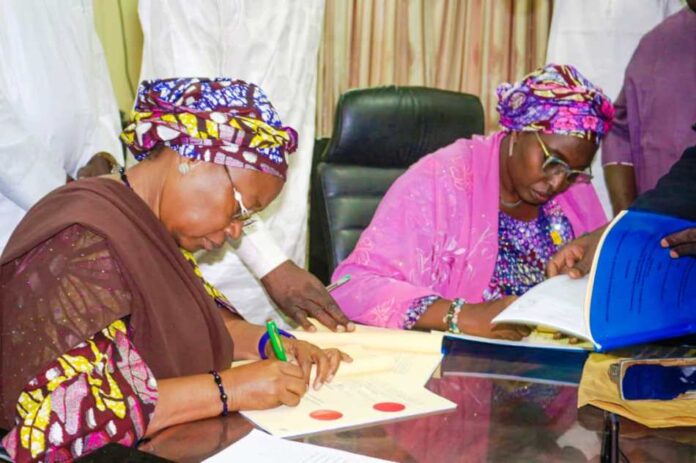 FG, Adamawa State Government Signs MoU 1 Signing of Memorandum of Understanding between the Federal Government and Adamawa State Government on the handover and conversion of Cottage Hospital Hong and General Hospital Mubi to Federal Medical Centres. L-R: The Deputy Governor of Adamawa State Prof. Kaletapwa Farauta signing the MoU; Permanent Secretary Federal Ministry of Health & Social Welfare Daju Kachollom mni, signs on behalf of the Federal Government.