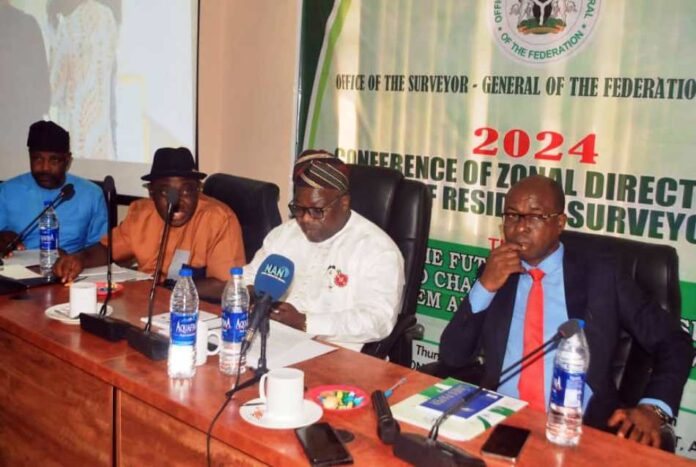 Conference Of Zonal Directors And Chief Resident Surveyors In white brocade is Surveyor General of the Federation Surv Abduganiyu Adeyemi Adebomehin delivering his welcome address at the event