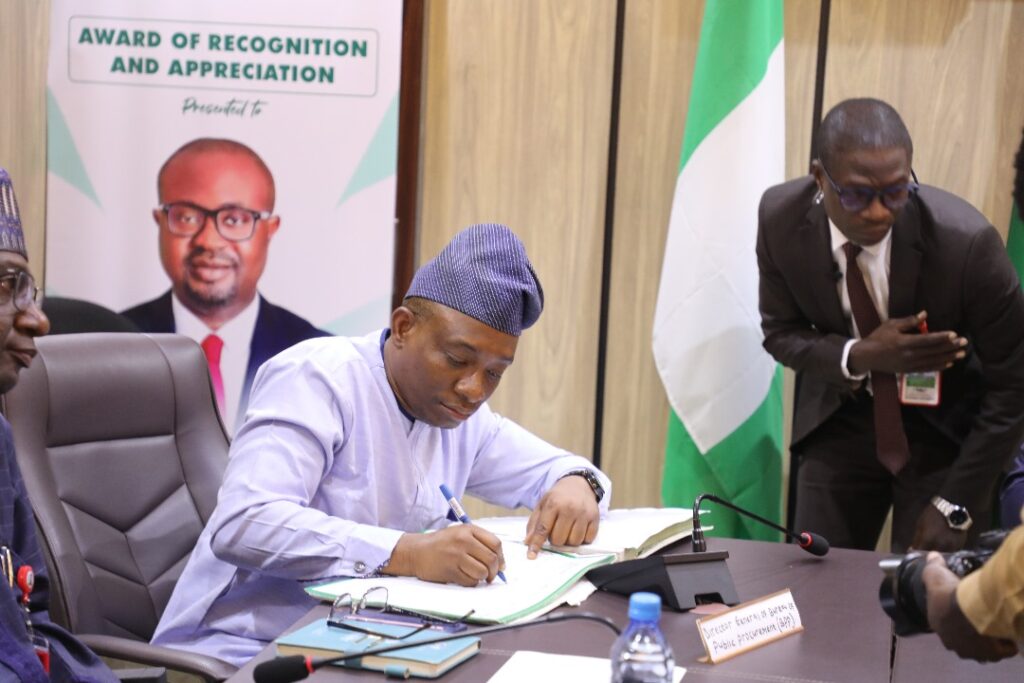 Dr. Adebowale Adedokun MCIPS, ACF, Director General, BPP signing visitors register during a courtesy call to the Federal Ministry of Interior
