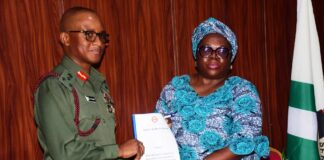 The Representative of the National Coordinator SERVICOM Presidency Office , Mr . Anthony oshin, Mrs Ngozi Akinbodewa presenting the report to the Director General National Youth Service Corps, Brigadier General Olakunle Nafiu, today at the NYSC Headquarters Office, Abuja